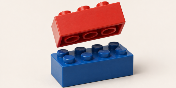 A red construction brick shown from underneath with visible tubes above a blue studded brick, illustrating the stud-and-tube principle.