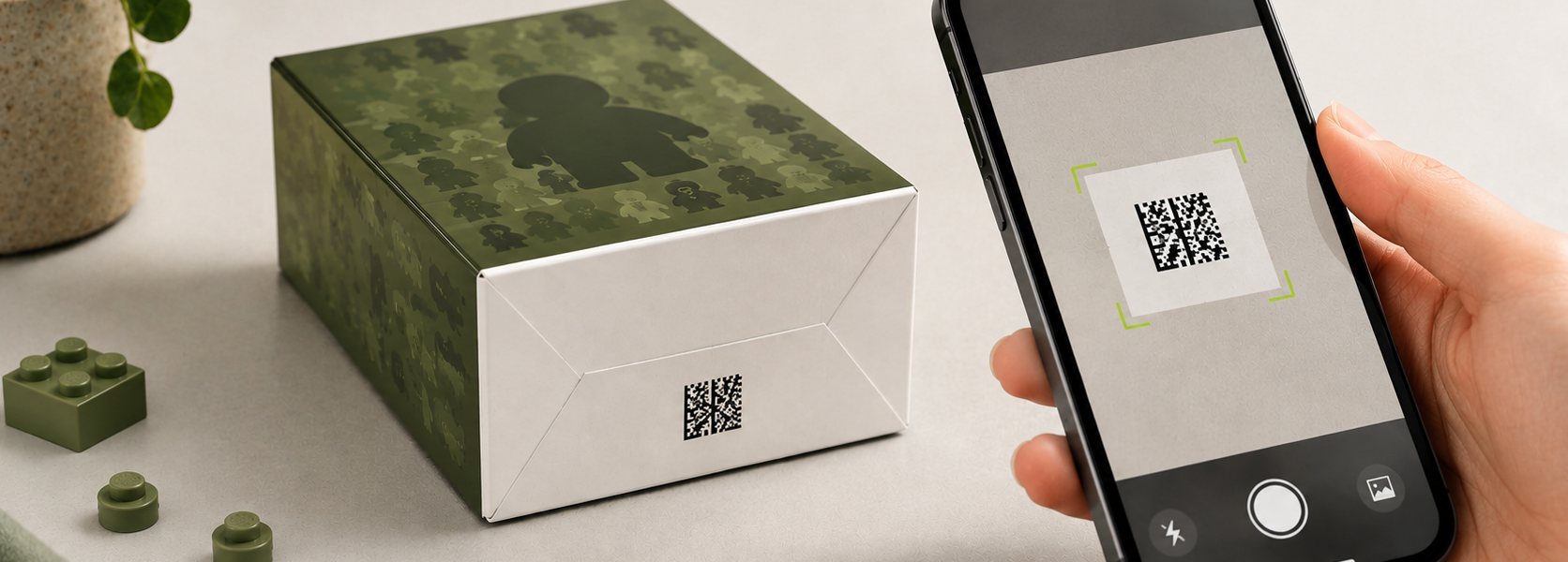 A hand holding a phone that scans a Data Matrix code on the bottom of a green-and-white collectible minifigure box.