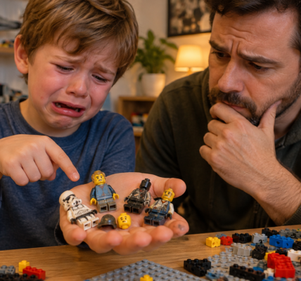 A tearful child shows a parent several damaged minifigures resting on an open palm at a table covered with bricks.
