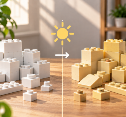 A side-by-side comparison of white building bricks and yellowed aged pieces, divided by a sun symbol and arrow illustrating light-related material aging.